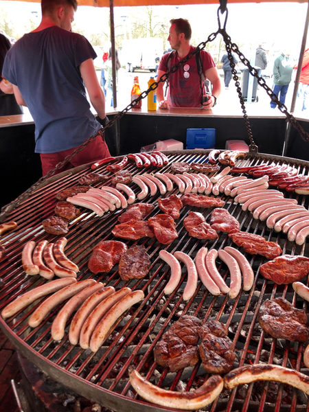 Würstchen und Steaks auf einem großen Schwenkgrill