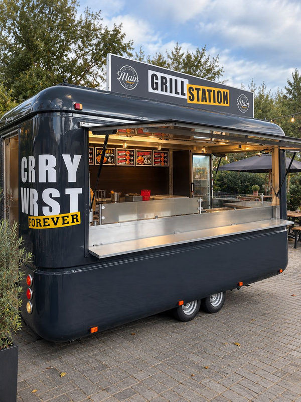 Grillstation im schwarzen Retro-Anhänger mit Currywurst-Schriftzug